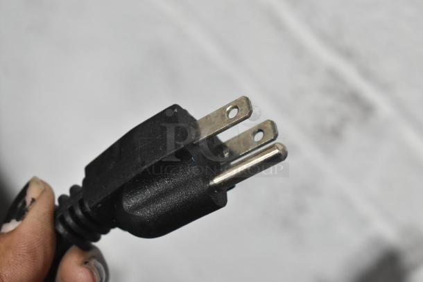 Close-up of a black three-pronged power plug from a 2023 Coldline ICE80-HA ice machine, 115V, 1 phase.