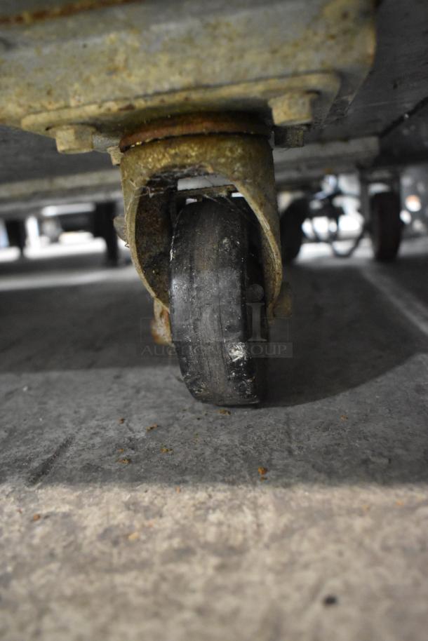 Commercial caster wheel on Avantco 178SSUC48FHC stainless steel undercounter freezer, showing wear and rust.