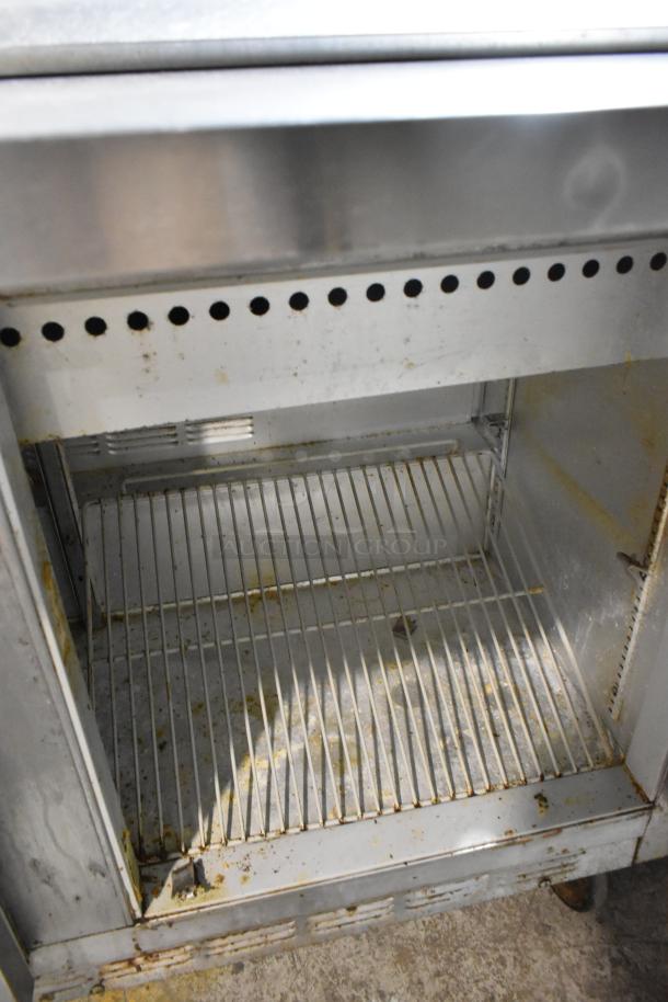 Beverage Air SP48-18M stainless steel prep table, visible shelf, worn condition, commercial casters, 115V, 1 phase.