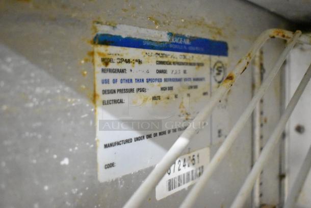 Beverage Air SP48-18M tag indicates model, refrigerant type, charge details, and power requirements. Rust evident on metal.