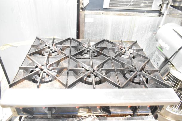 Star Max stainless steel commercial countertop 6-burner gas range on equipment stand, visible wear.