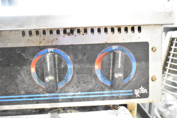 Star Max stainless steel commercial gas 6-burner range, used condition, control knobs with Star logo, mounted on stand.
