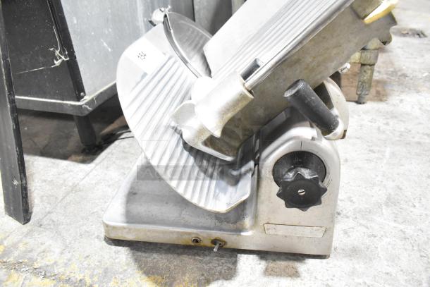 Metal commercial countertop meat slicer, 115 volts, 1 phase. Visible dial and blade. Used condition.