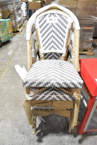 Stack of three brand new wicker style chairs, partially wrapped, with gray and white chevron pattern showing few scratches.