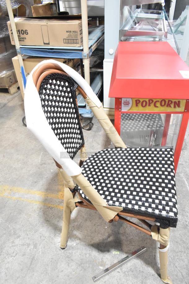 Brand new wicker style chair with black and white checkered pattern, partially wrapped in protective material, scratch and dent condition.