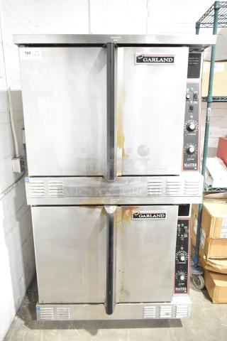 Pair of Garland Master 200 stainless steel commercial convection ovens with solid doors, metal racks, and thermostatic controls.