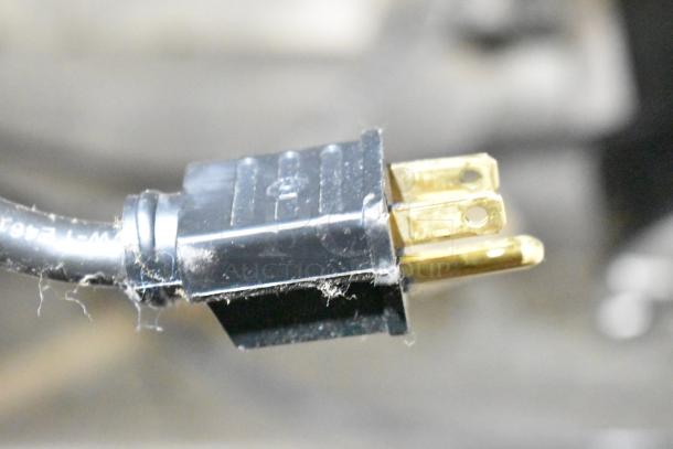 Close-up of electrical plug for Garland Master 200 commercial convection oven, highlighting metal prongs and black plastic casing.