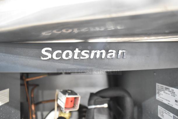 Scotsman C0830SA-32D stainless steel ice machine interior, visible label indicates model, pipes and wiring detail shown.