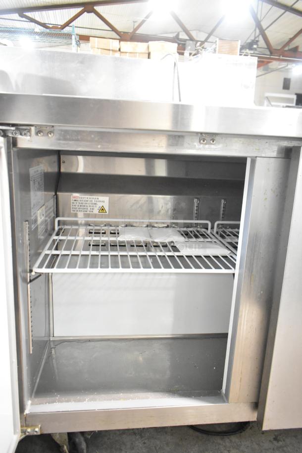 Avantco 178AWT48FHC commercial stainless steel work top freezer, two doors, on casters. Interior shelving visible.