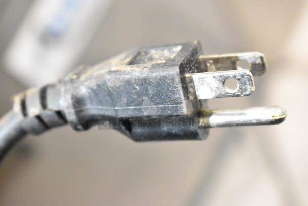 Close-up of a plug for the Avantco 178AWT48FHC stainless steel commercial 2 door work top freezer, showing standard 115V connection.