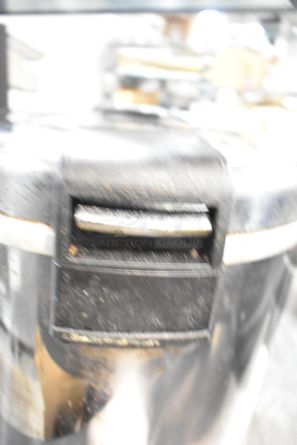 Stainless steel countertop electric rice warmer, electrical plug visible, used condition. Brands: Thundergroup SEJ-22000 and Zojirushi THA-803S.