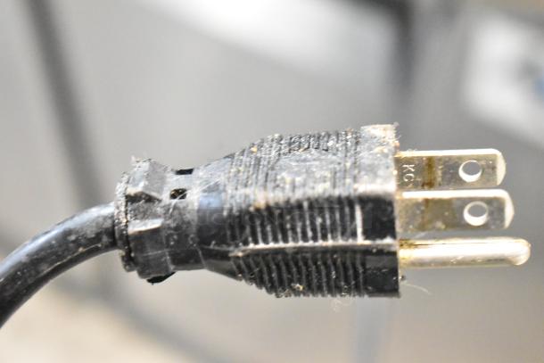 Close-up of a worn electric plug, part of stainless steel countertop electric rice warmers including Thundergroup SEJ-22000 and Zojirushi THA-803S.
