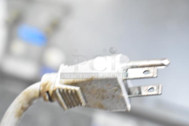 Close-up of a slightly worn electrical plug from the Hoshizaki HNC-210AA-L Sushi Display Case. 115 Volts, 1 Phase.