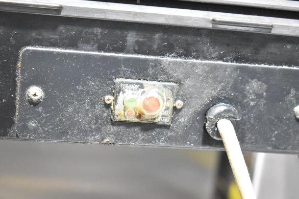 Close-up of Hoshizaki HNC-210AA-L sushi display case power switch area, showing wear and labels. Model HNC-210AA-L.