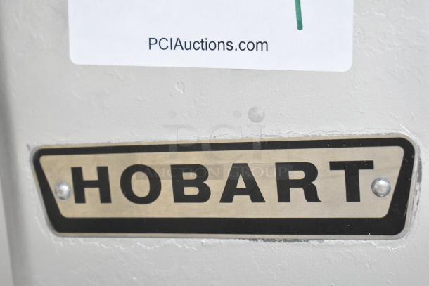 Hobart metal commercial floor meat saw, showing brand label, well-maintained, sturdy construction.