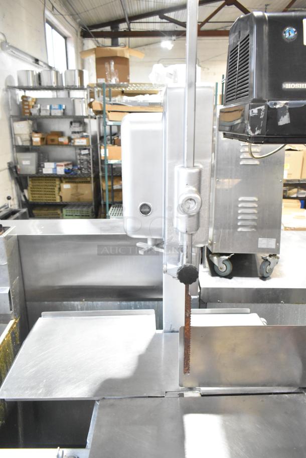 Hobart commercial metal floor meat saw, sturdy build, visible wear, ideal for high-volume meat processing.