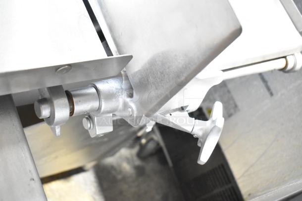 Hobart metal commercial floor-style meat saw, featuring sturdy metal construction, handle mechanism shown in close-up.