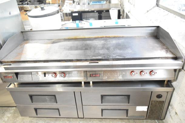 Lang stainless steel commercial countertop flat top griddle with thermostatic controls on 6-drawer chef base. Visible wear.