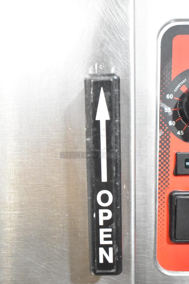 Vulcan stainless steel steam cabinet handle with "Open" label, adjacent to a control panel with timer.