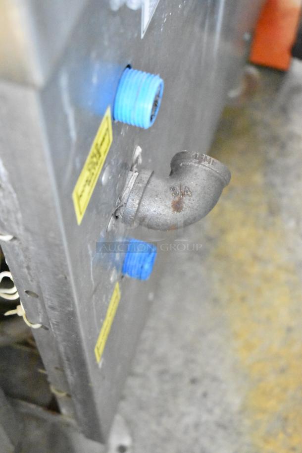 Vulcan stainless steel commercial steam cabinet connector detail, visible wear, labeled with size markings, industrial use.