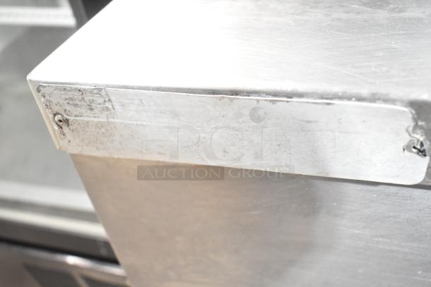 Vulcan stainless steel commercial steam cabinet corner with visible wear and a partially legible label.
