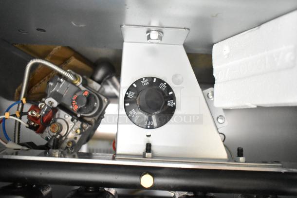 Interior view of Avantco 177FF50N deep fat fryer controls, showcasing temperature dial and gas components.