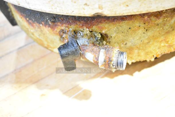 Rusty metal countertop rice cooker valve with visible corrosion and wear, indicating poor condition.