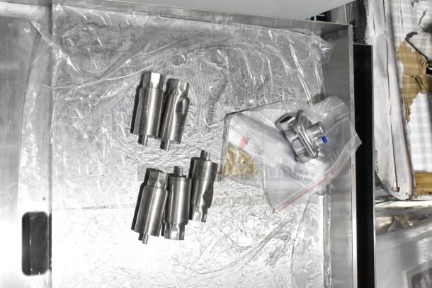 BRAND NEW SCRATCH AND DENT Cooking Performance Group gas griddle components on protective plastic, showing stainless steel parts.