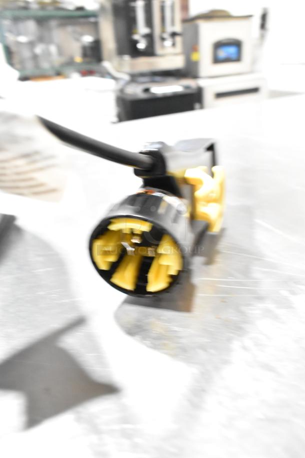 Alt text: Close-up of a power plug for a ProTeam 1076770 GoFit 6 PH Backpack Vacuum, 120 Volts, showing prongs and cord.