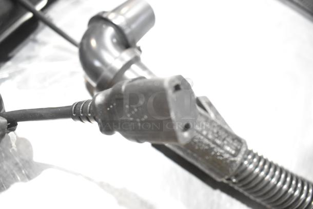 Close-up of a plug and hose for ProTeam 1076770 GoFit 6 PH Backpack Vacuum, 120 volts, 1 phase. Brand new condition.