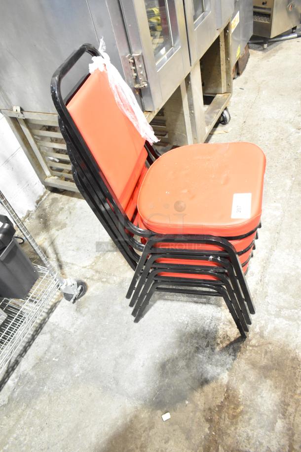 4 black metal dining chairs with red cushions, brand new with minor scratches and dents, stacked indoors.