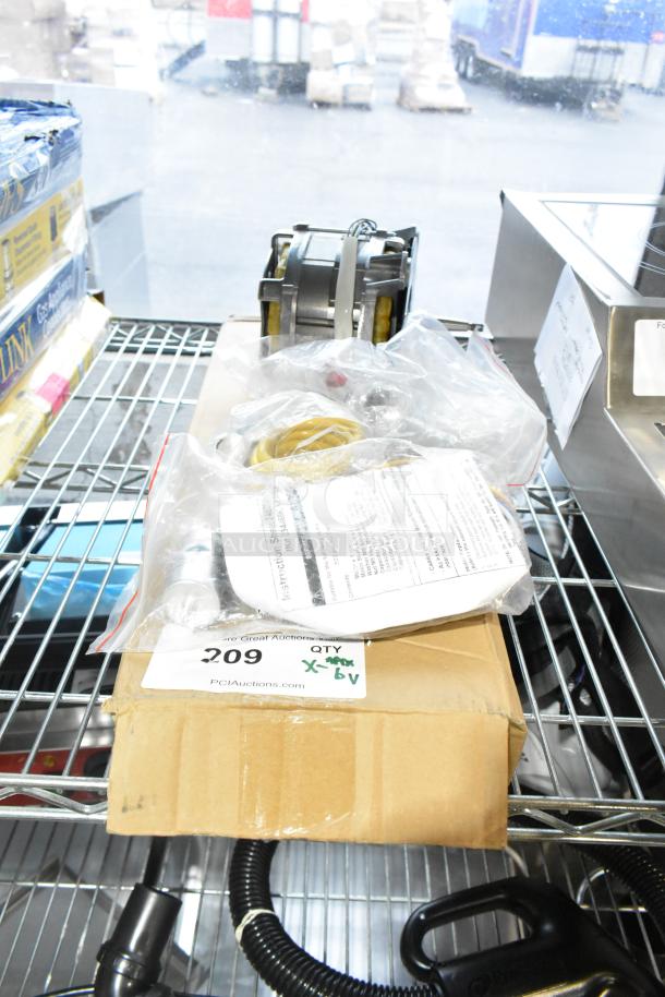 New scratch and dent items including a gas kit 089-010833-45, restraining cable, and Hanning motor on a shelf. Box tag reads "209 QTY X-6V."