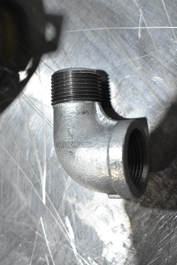 Metal elbow pipe fitting, new, threaded ends, part of a scratch and dent auction set.