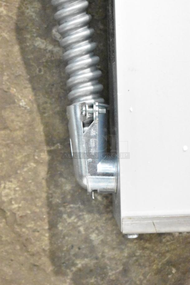 Close-up of the connector and coiled wire on a ServIt 423SW60TLHDBLA 60" lighted double strip warmer.