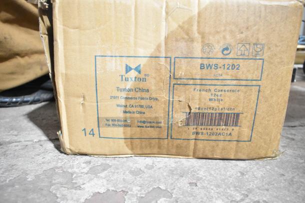 Cardboard box marked Tuxton BWS-1202, containing 12 oz. white china French casserole dishes, 12 per case, scratch and dent.