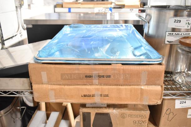 Two new Carlisle 2618FMTQ309 black fiberglass market trays in boxes, 18"x26"x1", with two full-size metal baking pans.