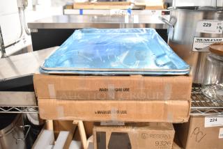 Two new Carlisle 2618FMTQ309 black fiberglass market trays in boxes, 18"x26"x1", with two full-size metal baking pans.