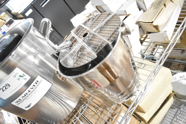 6 brand new kitchen items, including Anchor Hocking Montana jar and Vollrath Wearever stock pot, on a metal shelf.