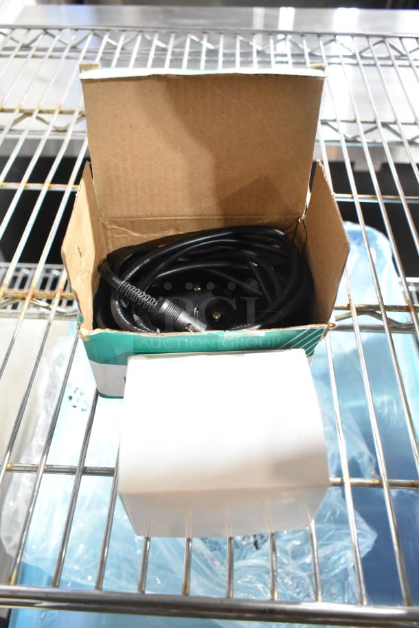 Box containing a coiled black cable on a metal shelf, part of a lot including Pentair filtration cartridges and other items.