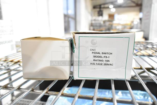 Boxes of CNC Pedal Switch Model FS-1, rated 10A, 250VAC. Items are brand new, displayed on a metal shelf.