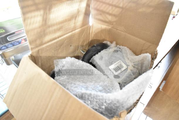 Cardboard box with 27 new caster components, models 35912011471 and 351302090156, wrapped in bubble wrap, visible barcode.