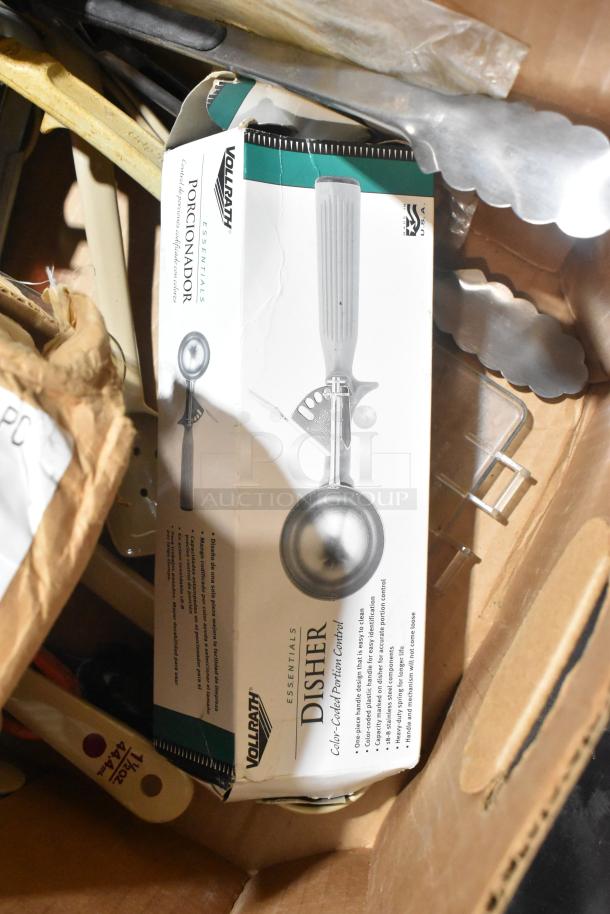 Box of brand new Vollrath 4780912 tongs, scoopers, and dippers, partially unpacked in cardboard box.