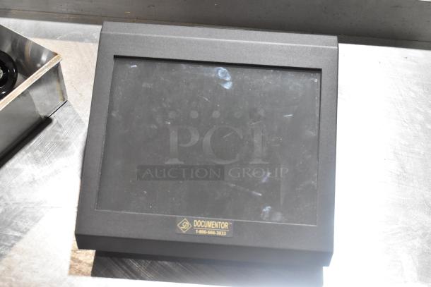 "Documentor TPOS1225 monitor with visible fingerprints, matte black finish, label indicating brand and contact number."