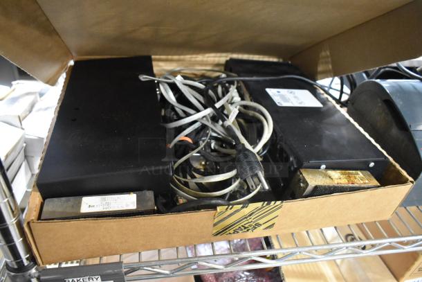 Box of various electronic items including POS monitors and receipt printers, featuring tangled wires and visible wear, valuable for resale or parts.