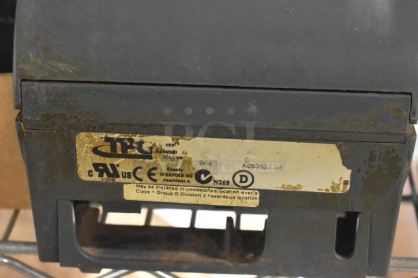 Close-up of TPG device with CE marking and "Assembled in Mexico" label, showing wear and rust on its surface.