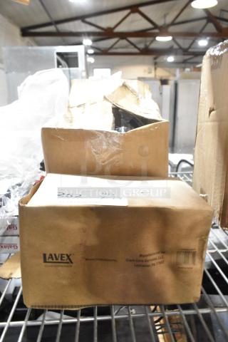 New Lavex 712SSSD40VL stainless steel soap dispenser in box on shelf. Box shows model and manufacturer details.