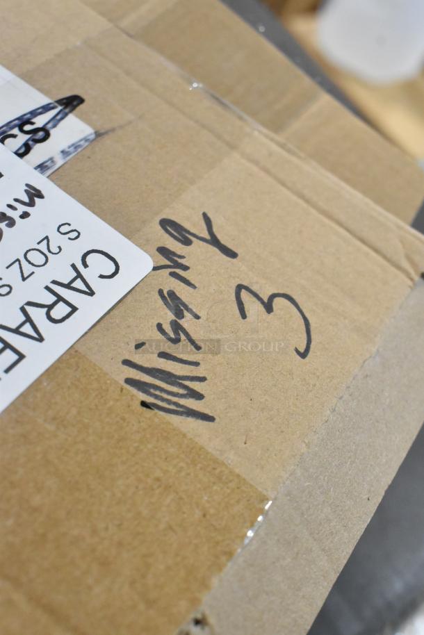 Cardboard box labeled "Carafe S202" with hand-written "Missing 3," indicating a new scratch and dent auction item including Acopa 4 oz. Glass Carafe.