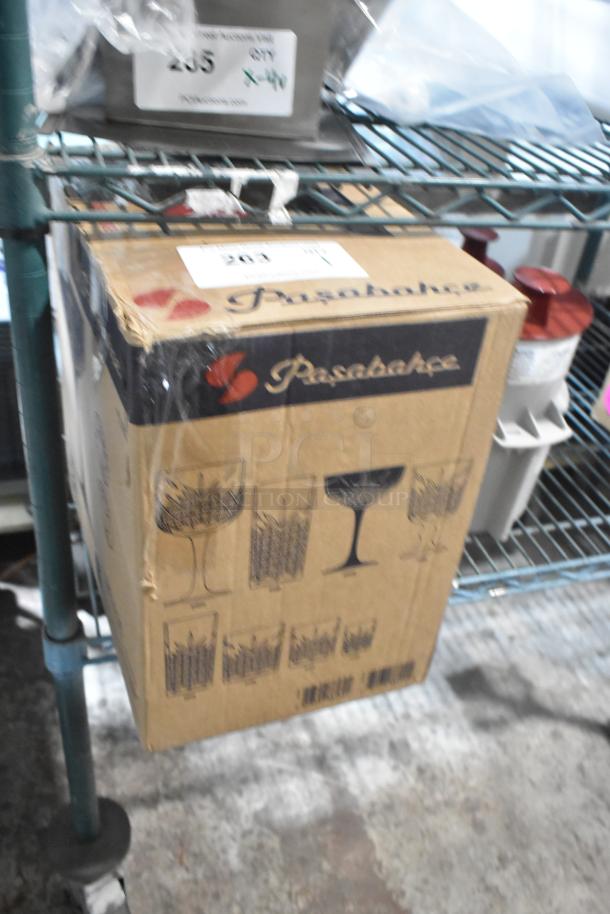 Box of 5 Pasabahce glasses, brand new, scratch and dent condition. Cardboard box shows glassware designs and Pasabahce logo.
