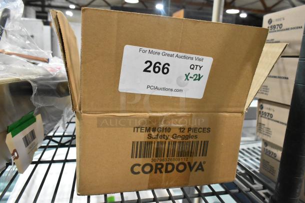 Cardboard box labeled "Cordova Safety Goggles, ITEM#GI10, 12 pieces" with auction info tag "PCI Auctions QTY X-2Y."