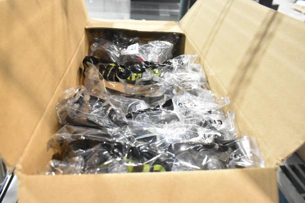 Box of assorted items including GOJO® 2730-12 TFX Black Touchless Soap Dispensers and Cordova Safety Goggles, packaged.